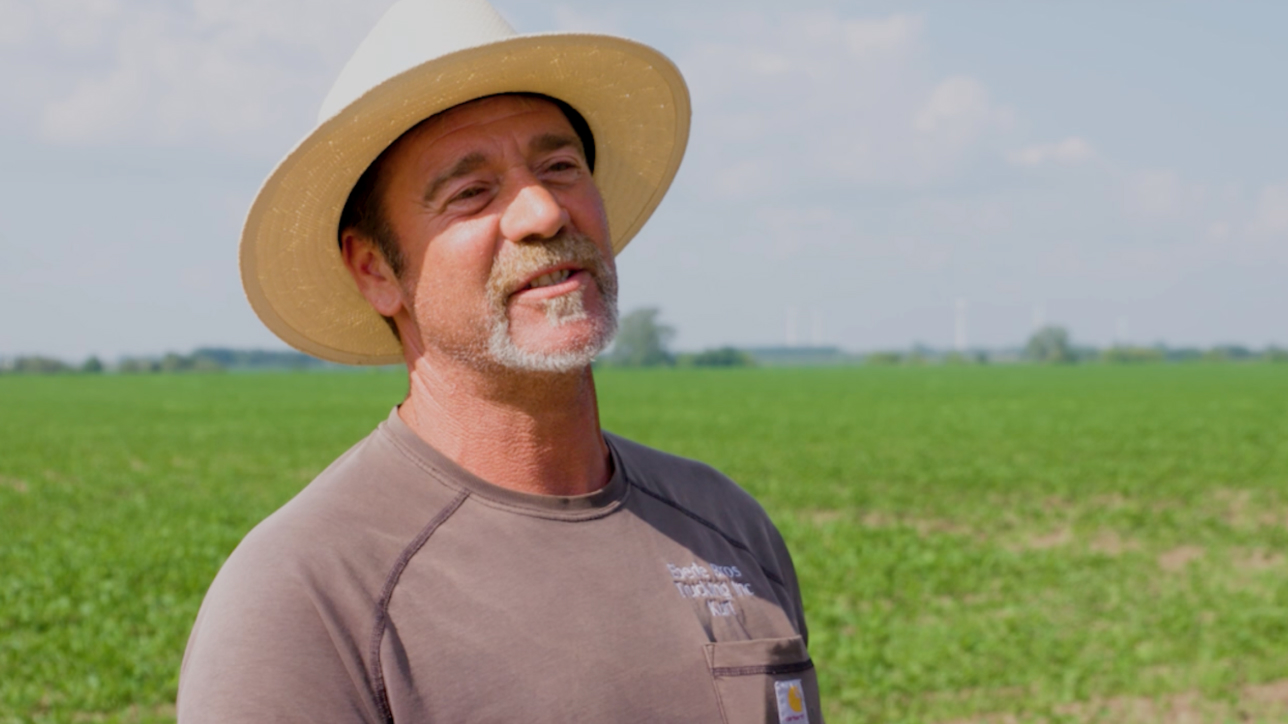 Man with brimmed hat and t shirt in field